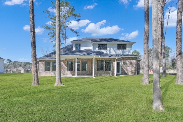 back of house featuring a yard and brick siding