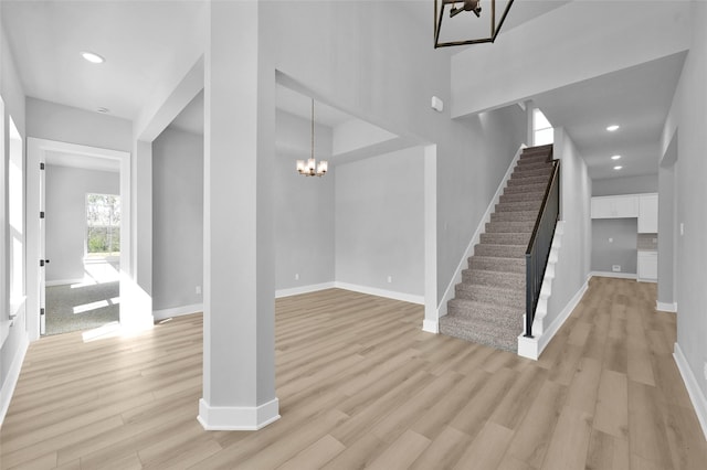 foyer entrance featuring light wood-style flooring, recessed lighting, baseboards, and a chandelier