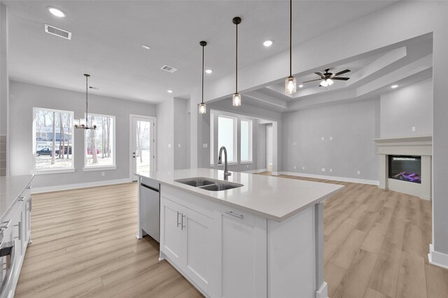 kitchen with a glass covered fireplace, visible vents, a sink, dishwasher, and open floor plan