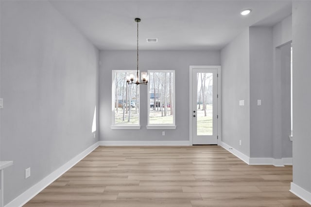 entrance foyer featuring a notable chandelier, light wood-style floors, visible vents, and baseboards