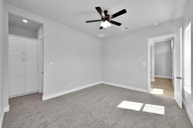 unfurnished bedroom with visible vents, baseboards, carpet, and a ceiling fan