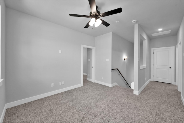 unfurnished room with carpet flooring, a ceiling fan, and baseboards