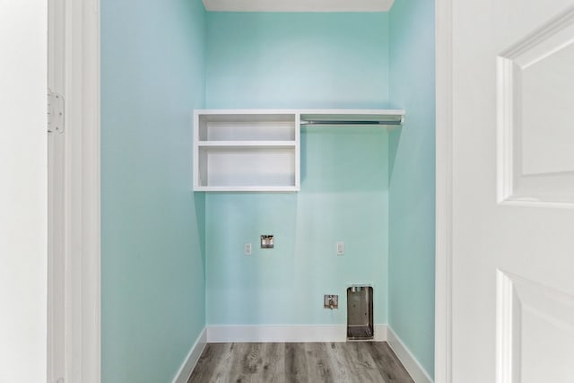 washroom with electric dryer hookup, baseboards, wood finished floors, and laundry area