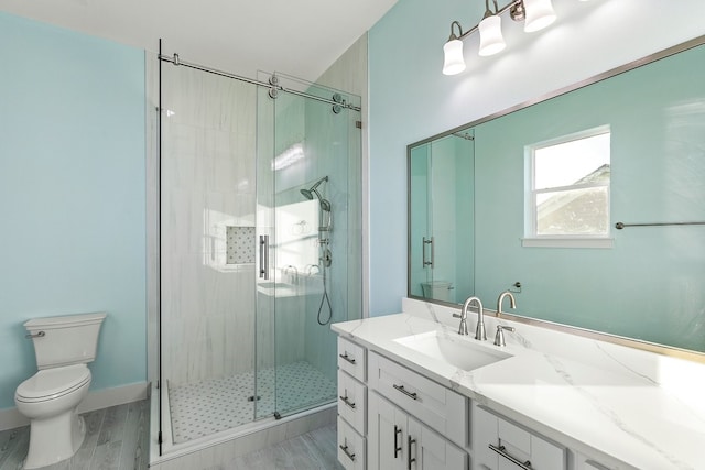 full bath featuring vanity, a shower stall, and toilet