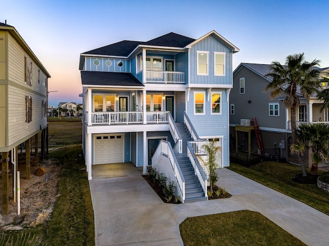 beach home with stairway, a garage, board and batten siding, and driveway