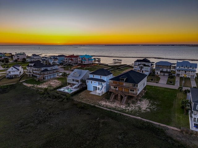 aerial view at dusk with a residential view and a water view