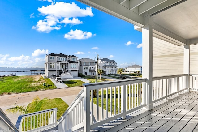 wooden terrace featuring a residential view and a water view