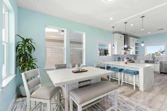 dining room featuring light wood finished floors, recessed lighting, and baseboards