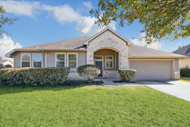 view of front of property featuring driveway, stone siding, a front yard, a shingled roof, and a garage