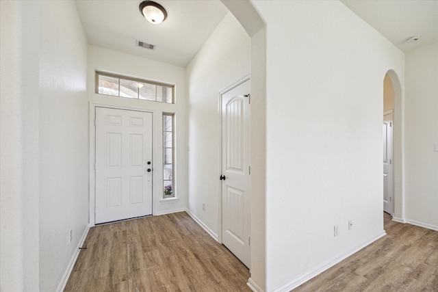 foyer entrance featuring light wood-type flooring, plenty of natural light, and visible vents