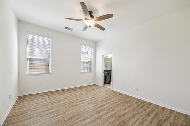 spare room featuring light wood-style flooring, baseboards, visible vents, and ceiling fan