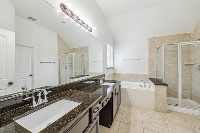 full bathroom with a sink, a stall shower, tile patterned floors, and vaulted ceiling