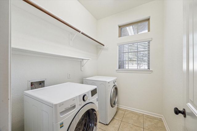 laundry room with laundry area, light tile patterned floors, baseboards, and independent washer and dryer