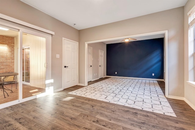 foyer entrance with ceiling fan, baseboards, and wood finished floors