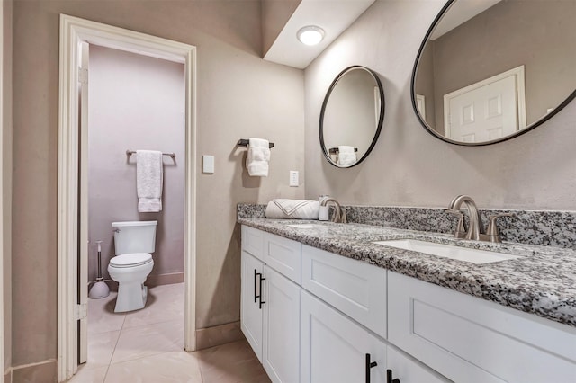 full bath featuring double vanity, toilet, baseboards, and a sink