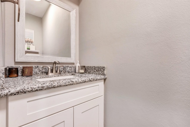 bathroom featuring vanity and a textured wall