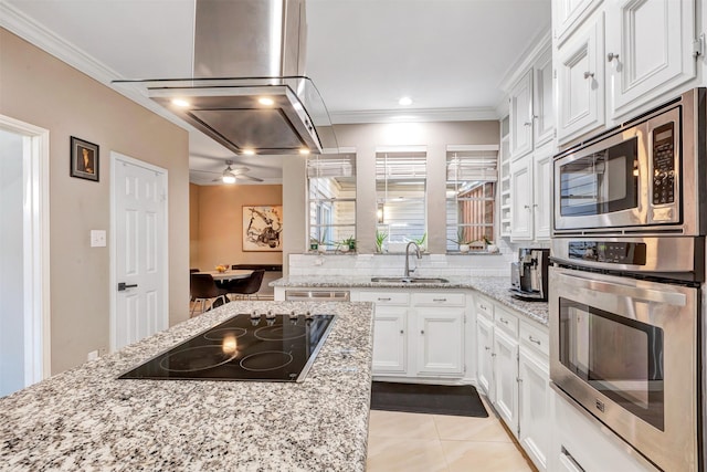 kitchen with ornamental molding, a sink, white cabinets, island range hood, and black electric cooktop