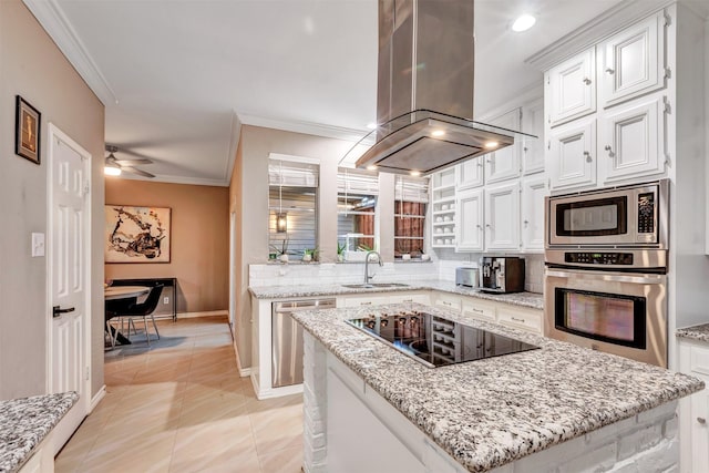 kitchen featuring crown molding, stainless steel appliances, island range hood, white cabinetry, and a sink