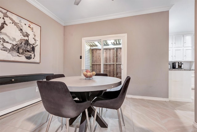 dining area with crown molding, light tile patterned floors, a ceiling fan, and baseboards