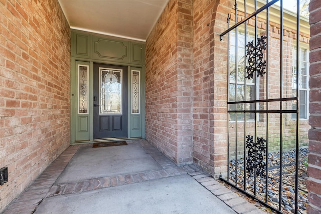 doorway to property featuring brick siding