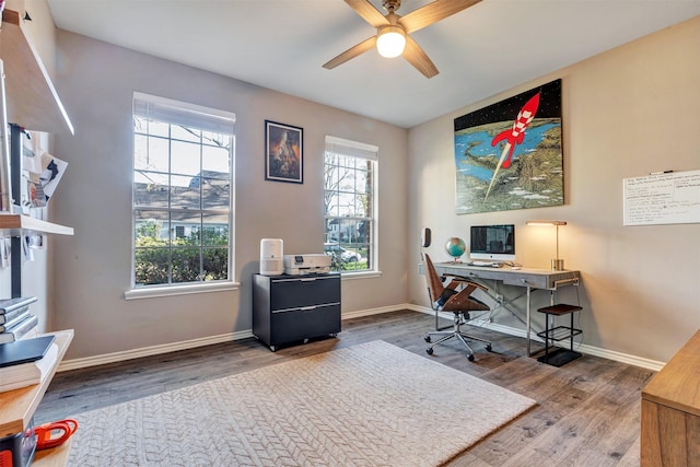 office space featuring baseboards, wood finished floors, and a ceiling fan