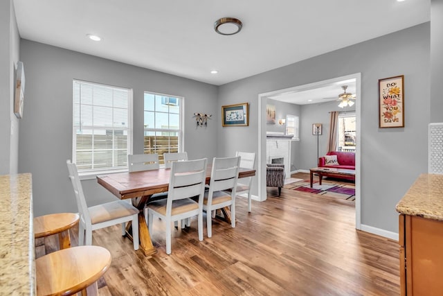 dining space featuring recessed lighting, light wood-style floors, baseboards, a brick fireplace, and ceiling fan