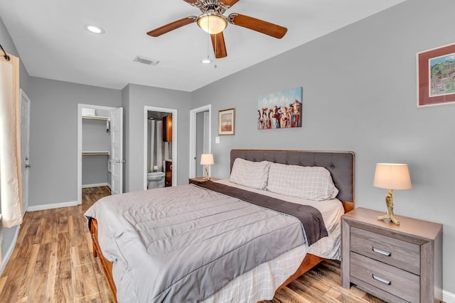 bedroom with visible vents, baseboards, recessed lighting, light wood-style floors, and a walk in closet