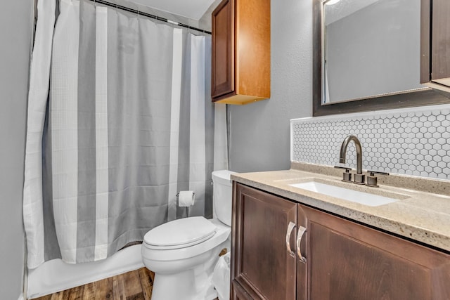 bathroom featuring toilet, wood finished floors, and vanity