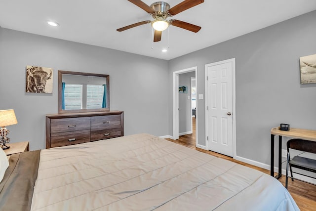 bedroom featuring a ceiling fan, recessed lighting, wood finished floors, and baseboards