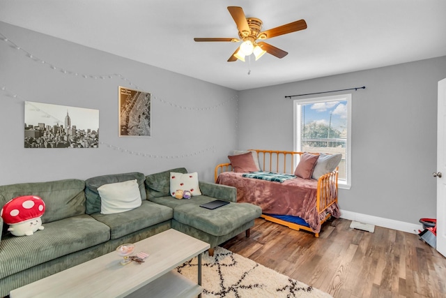 living area featuring baseboards, wood finished floors, and a ceiling fan