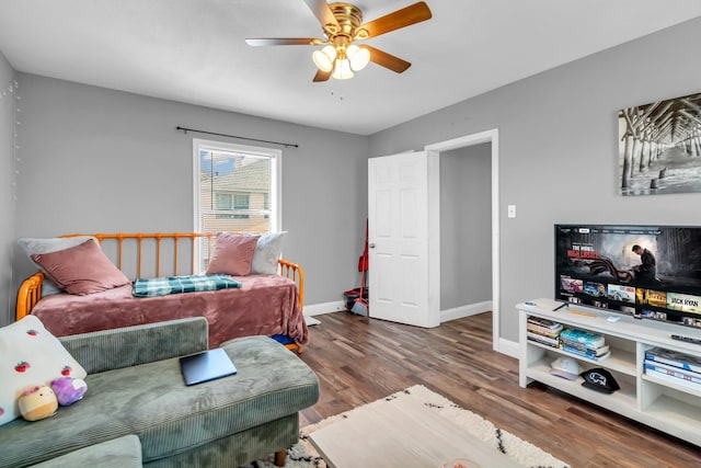 living area with ceiling fan, baseboards, and wood finished floors