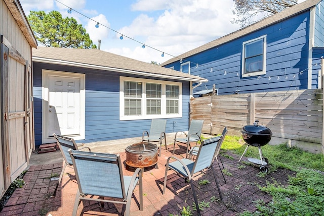 view of patio with grilling area, an outdoor fire pit, and fence