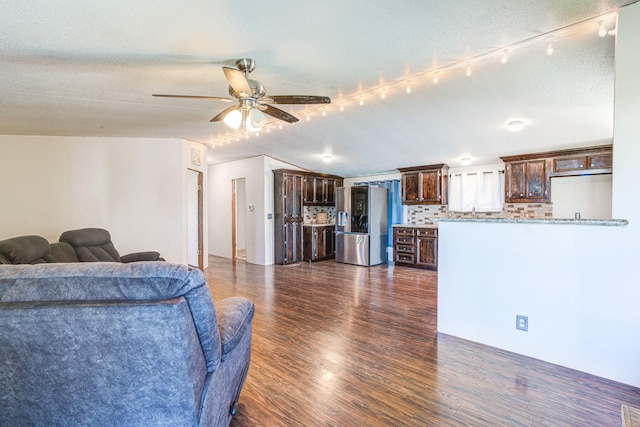 living area with dark wood-style floors, ceiling fan, and lofted ceiling