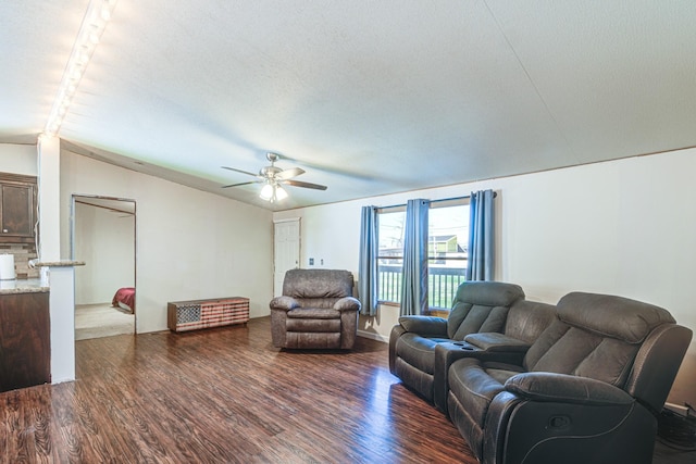 living room featuring ceiling fan, a textured ceiling, lofted ceiling, and wood finished floors