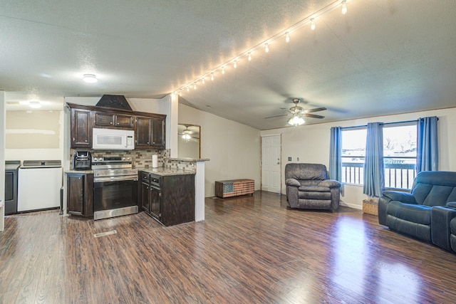 kitchen featuring white microwave, stainless steel range with electric cooktop, dark brown cabinetry, dark wood-type flooring, and open floor plan