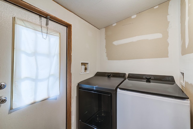 laundry room featuring laundry area, washer and dryer, and a textured ceiling