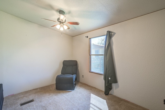 unfurnished room featuring visible vents, a textured ceiling, carpet, and a textured wall