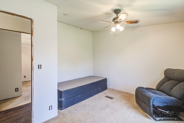 living area featuring carpet floors and ceiling fan