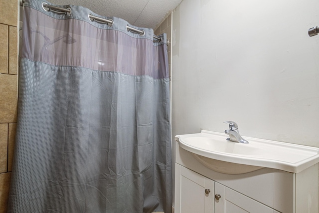 full bath with curtained shower, a textured ceiling, and vanity