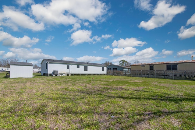 rear view of property with a yard and fence