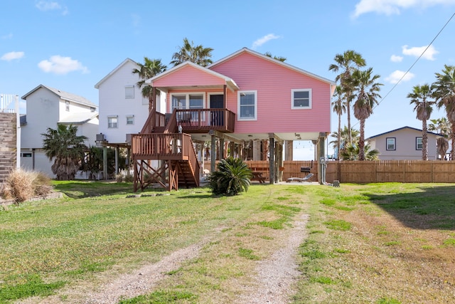 rear view of house featuring stairs, a yard, and fence