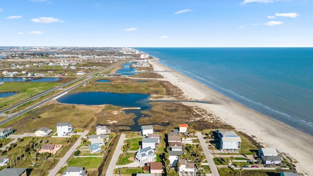 birds eye view of property with a water view and a beach view