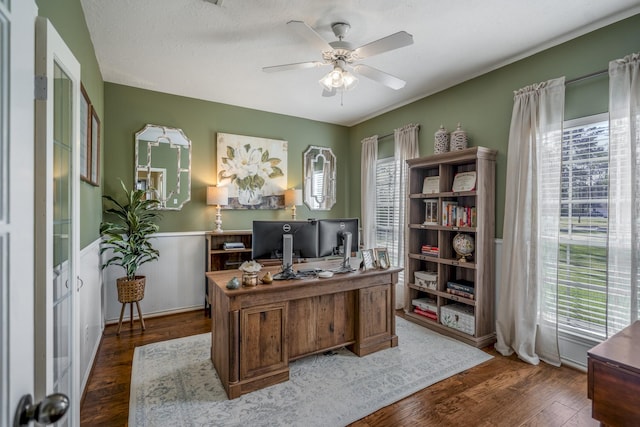 office space with a ceiling fan, dark wood-style floors, and wainscoting