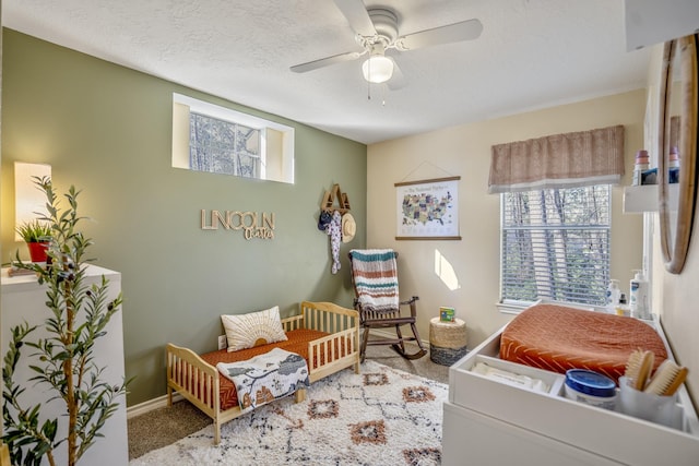 bedroom with baseboards, a textured ceiling, carpet, and a ceiling fan