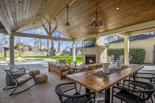 view of patio featuring an outdoor living space with a fireplace, a fenced in pool, outdoor dining space, and fence