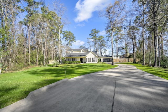 view of front of home with concrete driveway and a front lawn