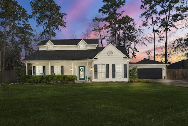 new england style home featuring fence, driveway, an attached garage, covered porch, and a lawn