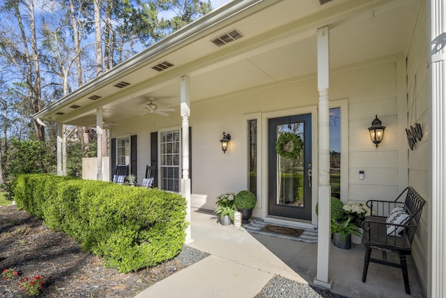 view of exterior entry featuring a porch and a ceiling fan