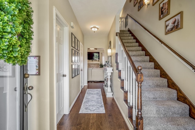 foyer with stairs, baseboards, and wood finished floors