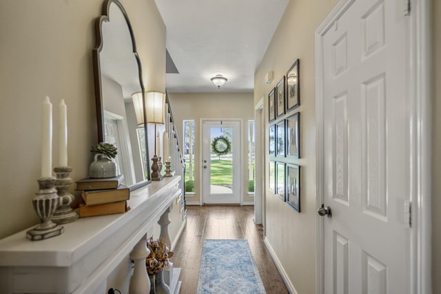 doorway to outside with dark wood-style floors and baseboards